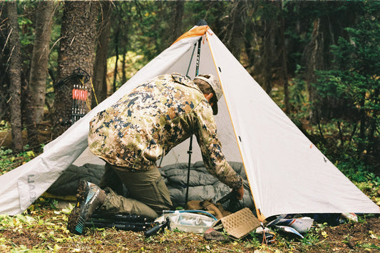 man going into tent to pull gear out